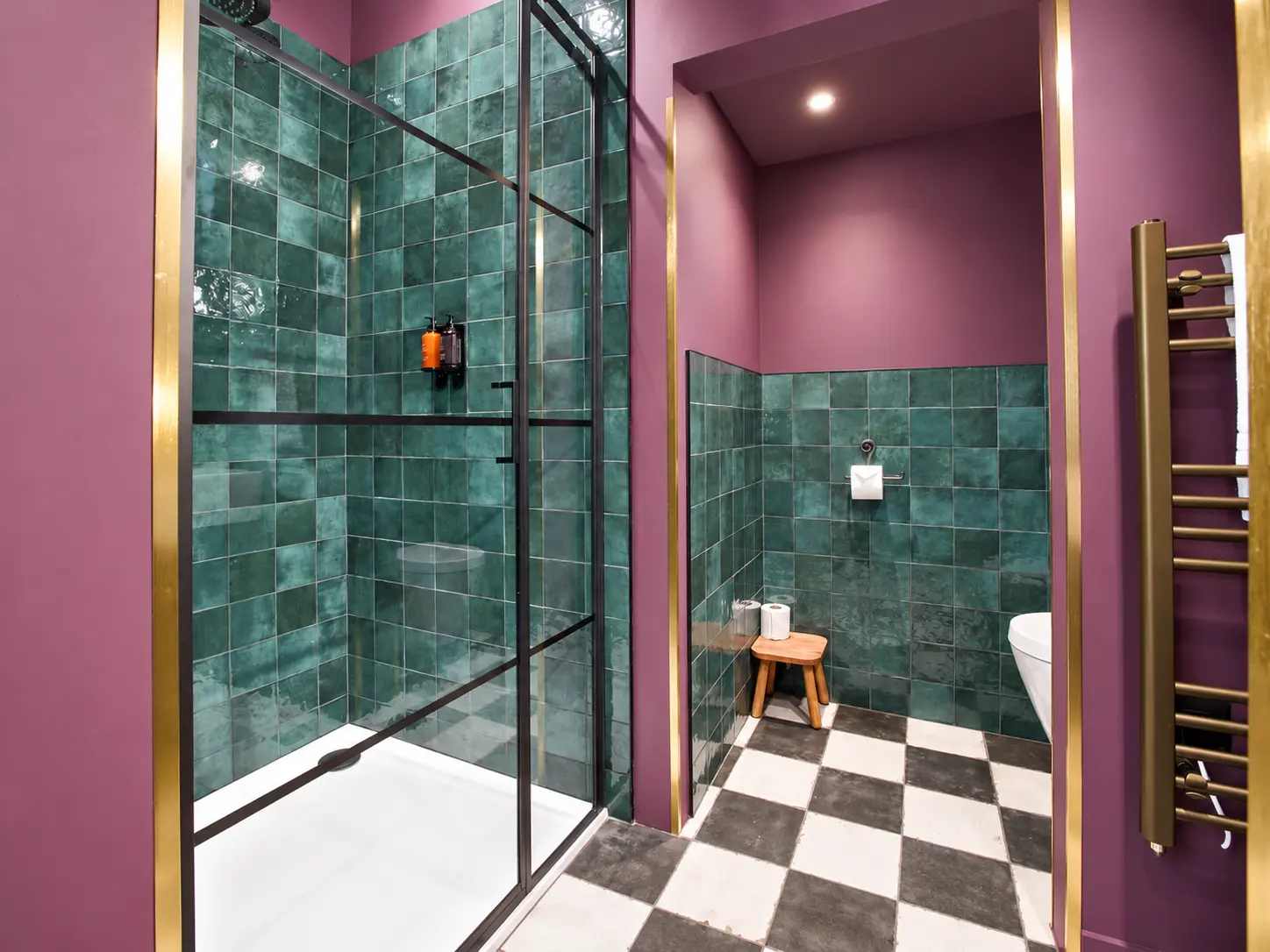 Bathroom renovation with green wall tiles, brass fittings and a glass shower screen